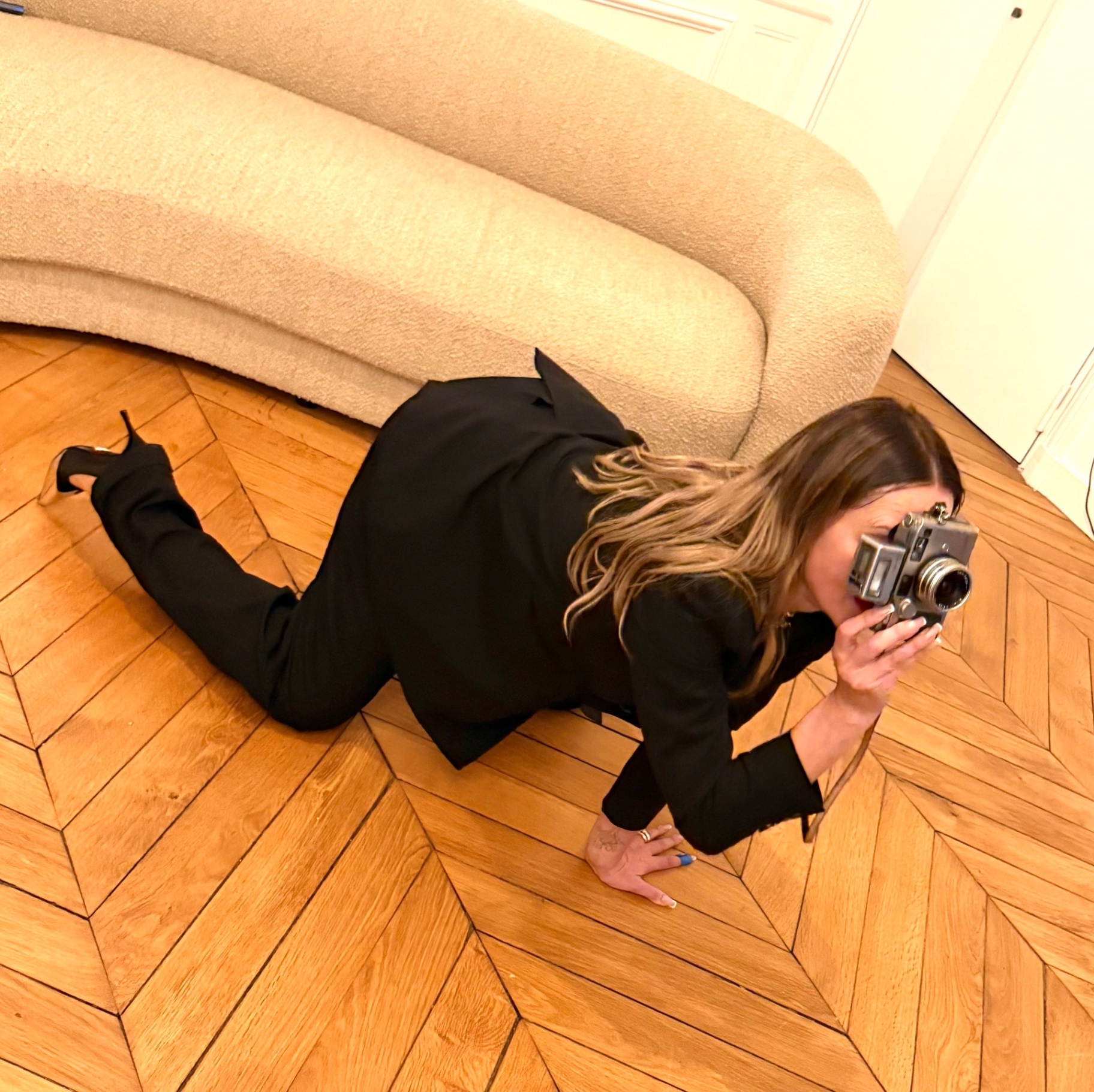Photographer Zuza Krajewska at work, lying on the parquet floor